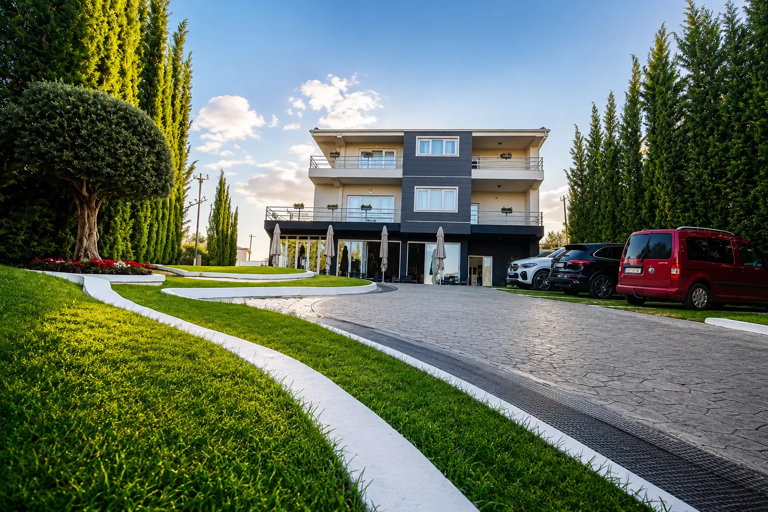 Three-storey hotel building seen across the lawn and driveway
