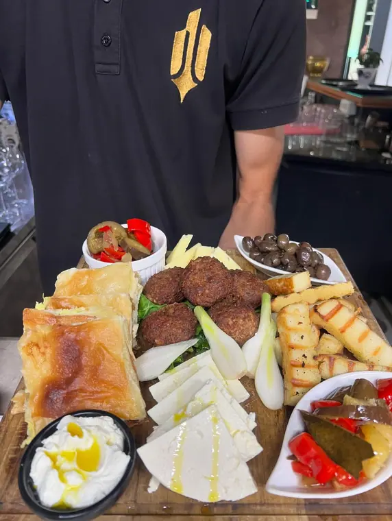 Breakfast board held at chest height with cheese and olives
