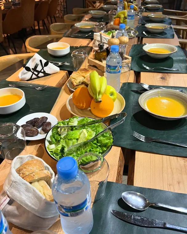 Close view of table with salad, dates, bread basket and soup