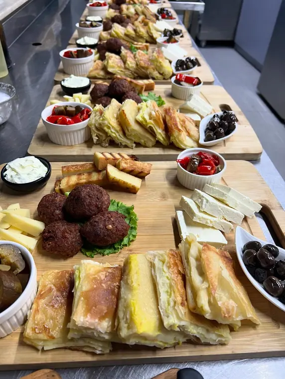 Line of served breakfast platters on a kitchen counter