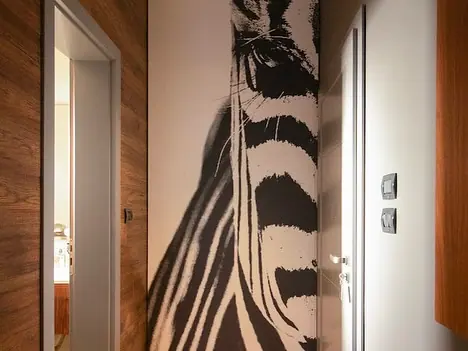 Corridor with zebra head mural and open bathroom door