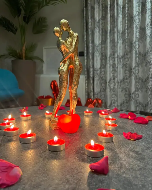 Gold embracing-couple figurine ringed by tealights and rose petals