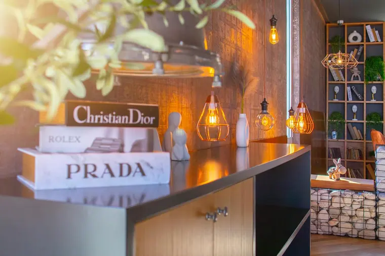Sideboard with stacked designer books and pendant bulbs
