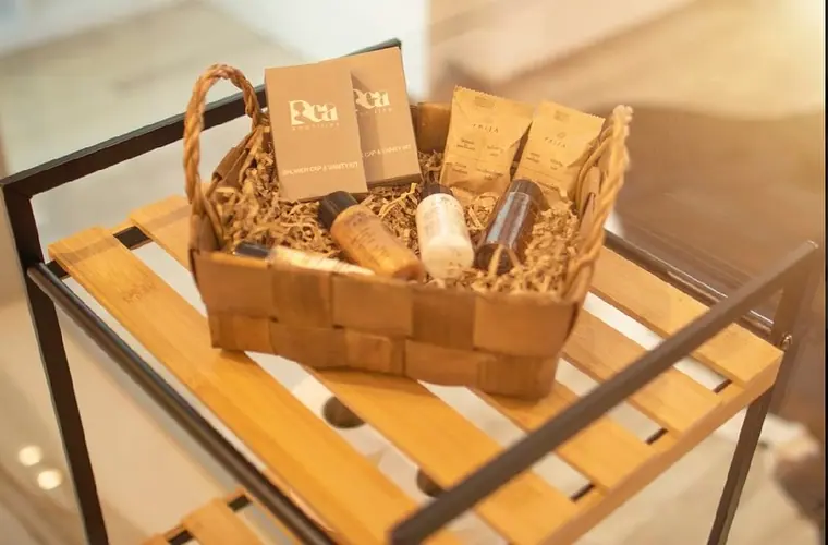 Wicker basket of toiletries and vanity kits on bamboo shelf