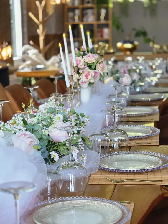 Banquet table with candlesticks, tulle runner and inverted glassware
