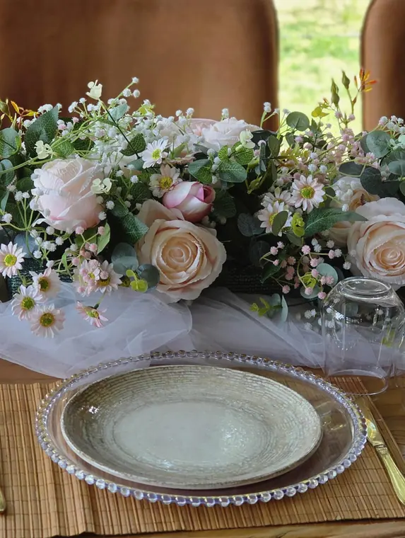 Close-up place setting with beaded charger plate and pink rose runner