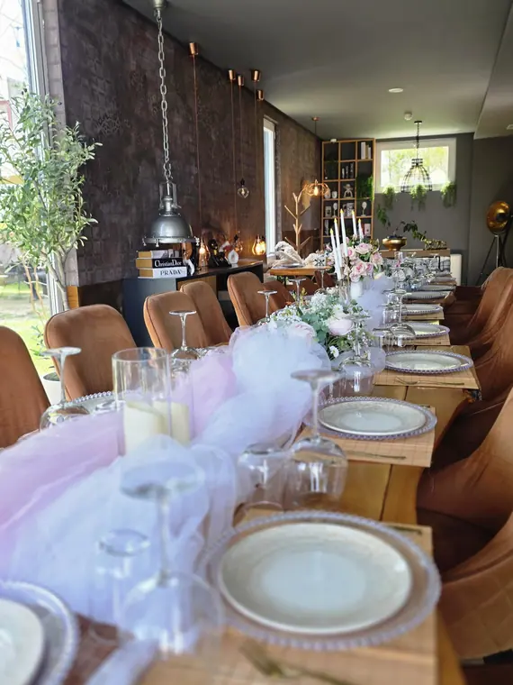 Dining room with long dressed table, tulle runner and pendant lights