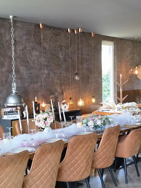 Long dressed table with tulle runner, floral centrepieces and tan velvet chairs