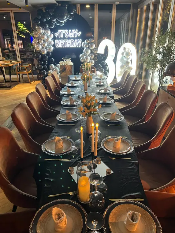 Long table with black cloth, silver chargers and candles