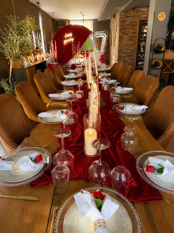 Long table with red velvet runner, candles and neon Happy Birthday sign