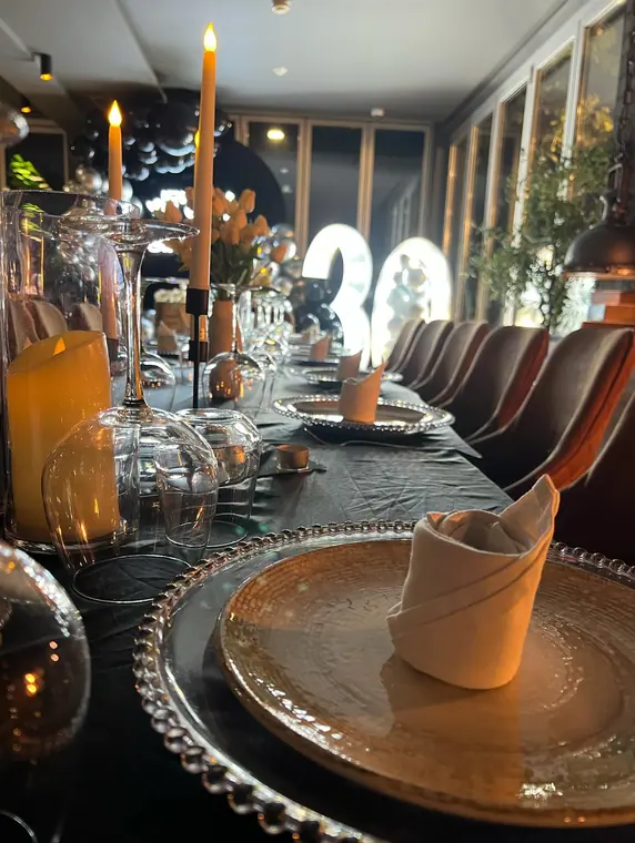 Place setting with folded napkin, candles and lit number 30 beyond