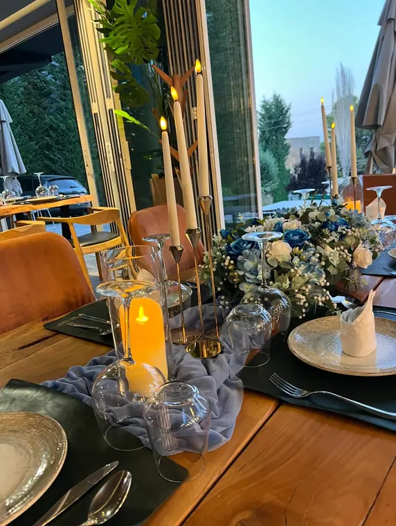 Dusk table setting with blue floral centrepiece and candlesticks
