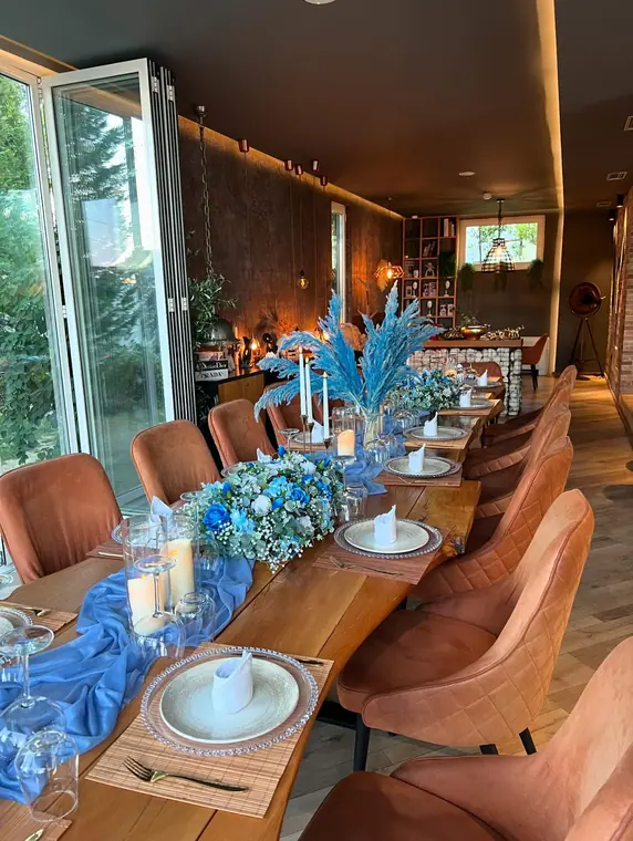Long table with blue chiffon runner, blue pampas and floral centrepieces