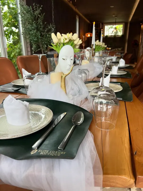 Place setting with green placemat, charger plate and mask centrepiece