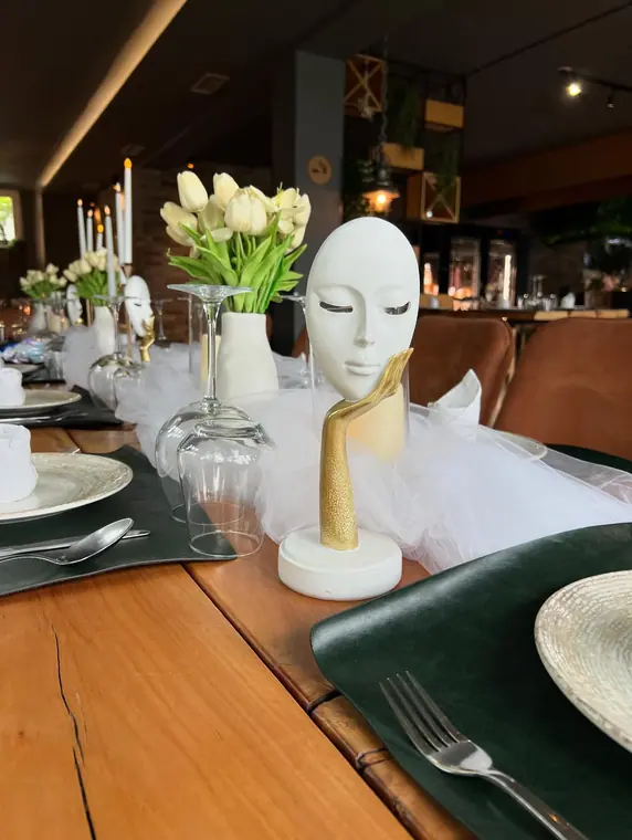 White face sculpture centrepiece on tulle runner along set table