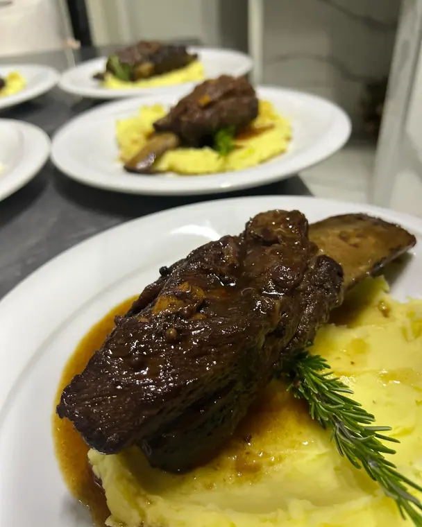 Braised short rib on mashed potato with rosemary, plated