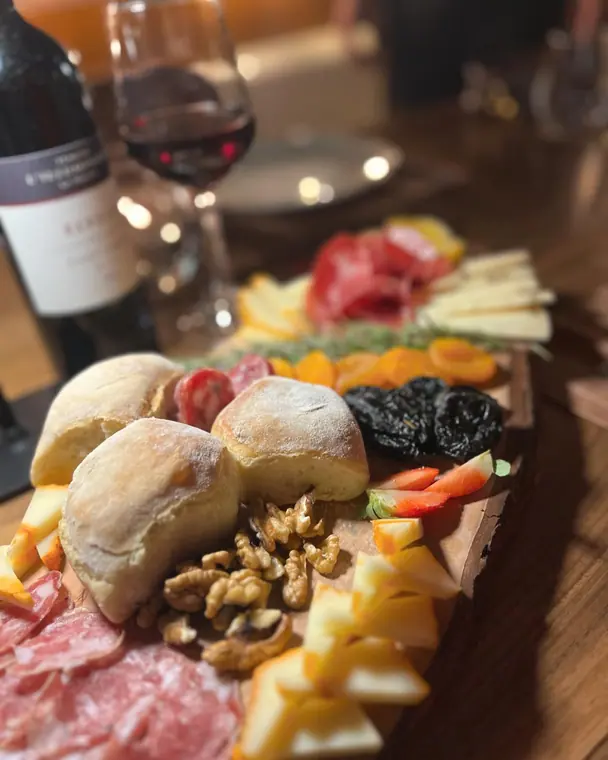 Charcuterie and cheese board with bread rolls, walnuts and dried fruit