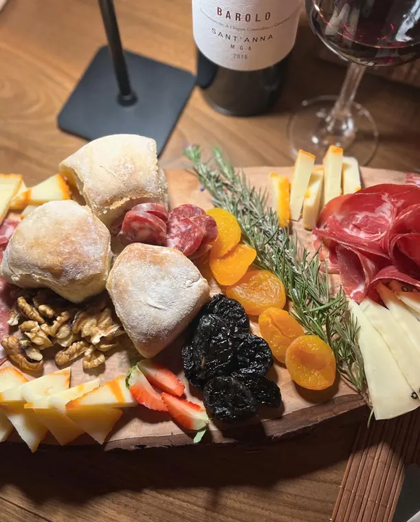 Cheese and cured meat board with bread and wine bottle