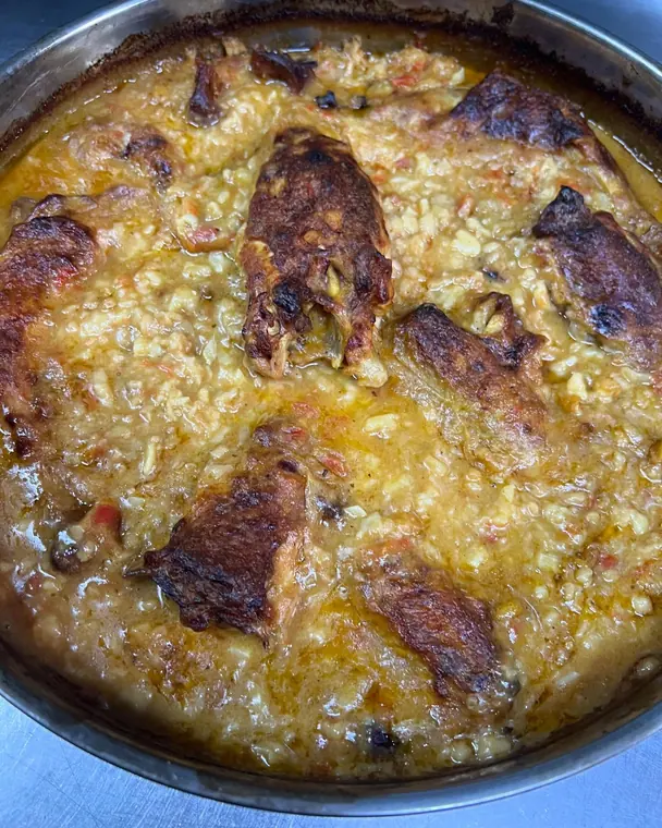 Close view of baked rice casserole with browned meat pieces