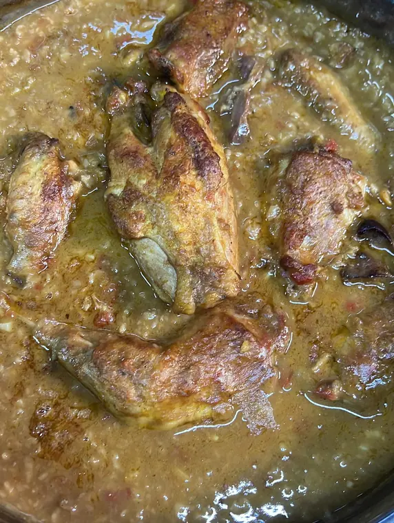 Close view of braised chicken pieces in sauce