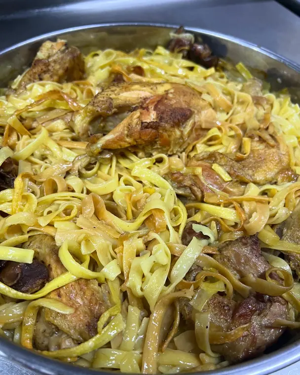 Close view of tagliatelle with roasted chicken in metal pan