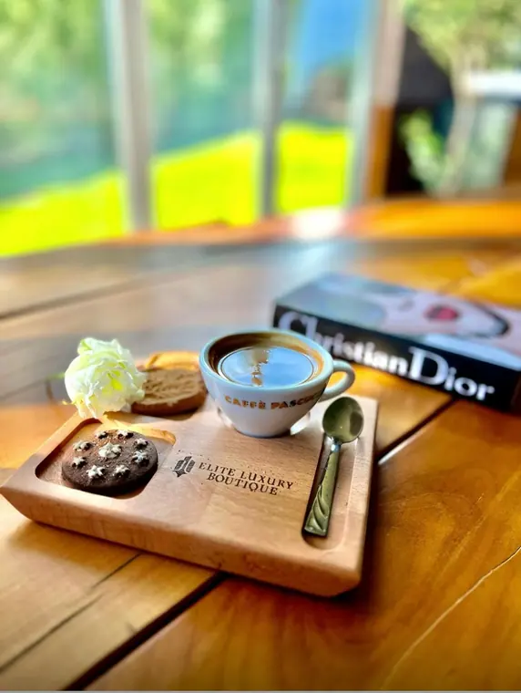 Coffee cup and biscuits on wooden board beside a book