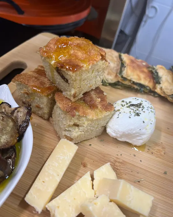 Cornbread squares, mozzarella, cheese wedges and pastry on a board