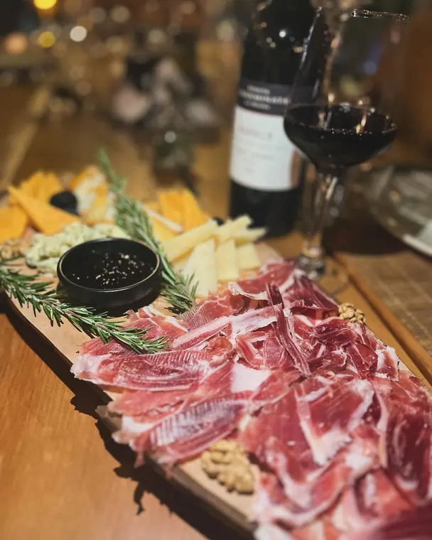 Cured ham and cheese platter with rosemary, walnuts and wine