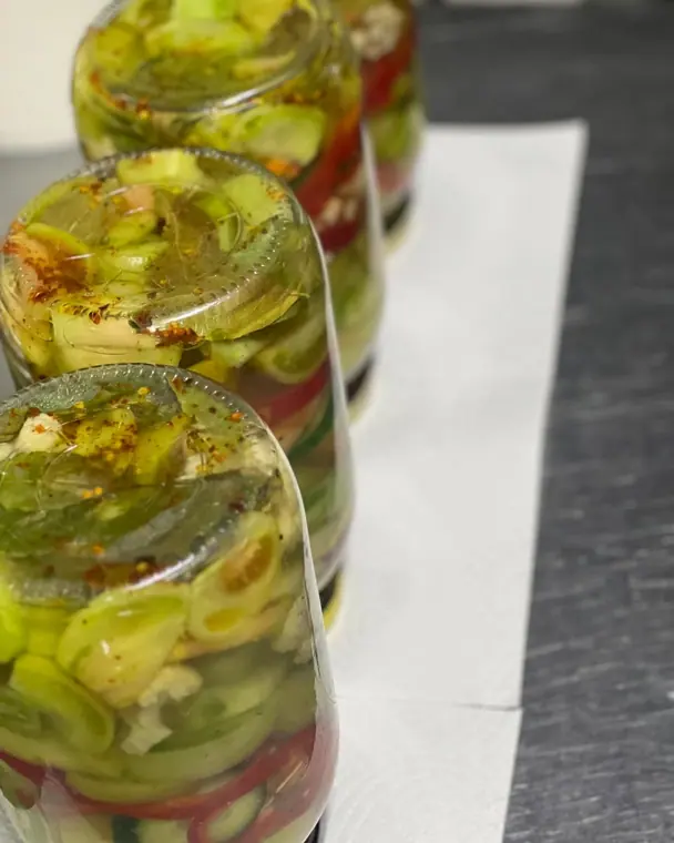 Inverted glass jars of pickled vegetables on paper towel