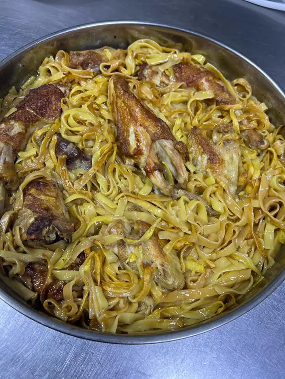 Pan of noodles topped with roasted chicken portions