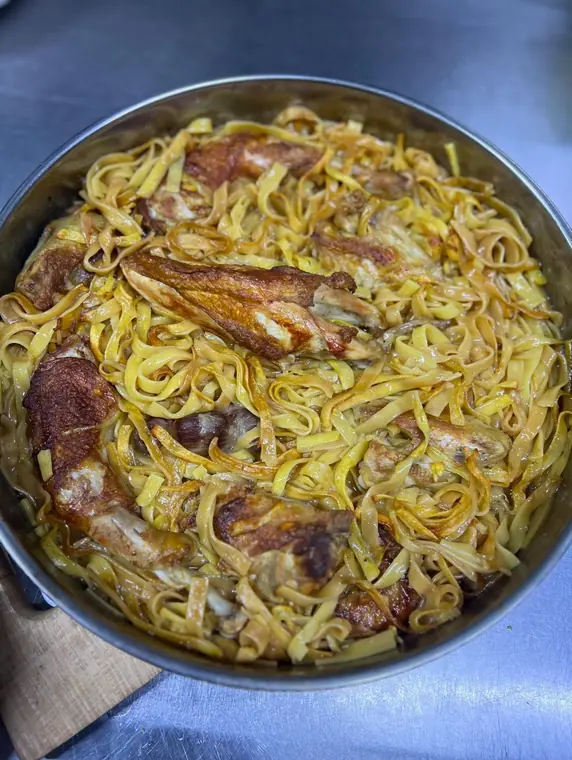 Pan of tagliatelle with browned chicken pieces