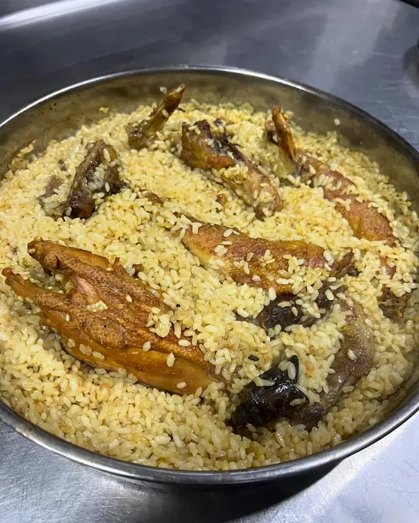 Pan of yellow rice with roasted chicken pieces