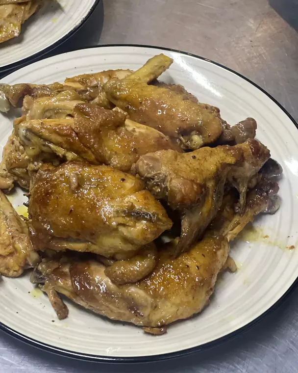 Plate of roasted chicken pieces with cooking juices