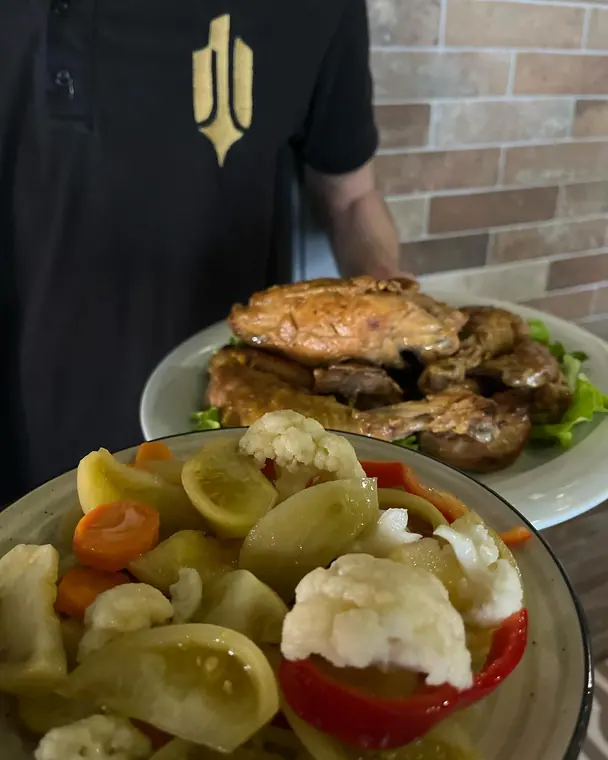 Roast meat on lettuce and bowl of pickled vegetables