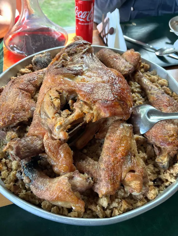 Roast poultry on bulgur, wine carafe behind