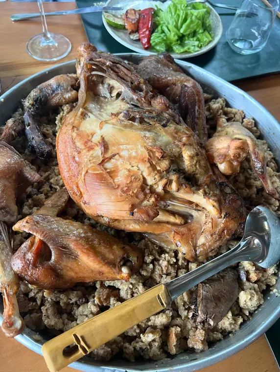 Roast poultry on bulgur with carving knife and salad behind