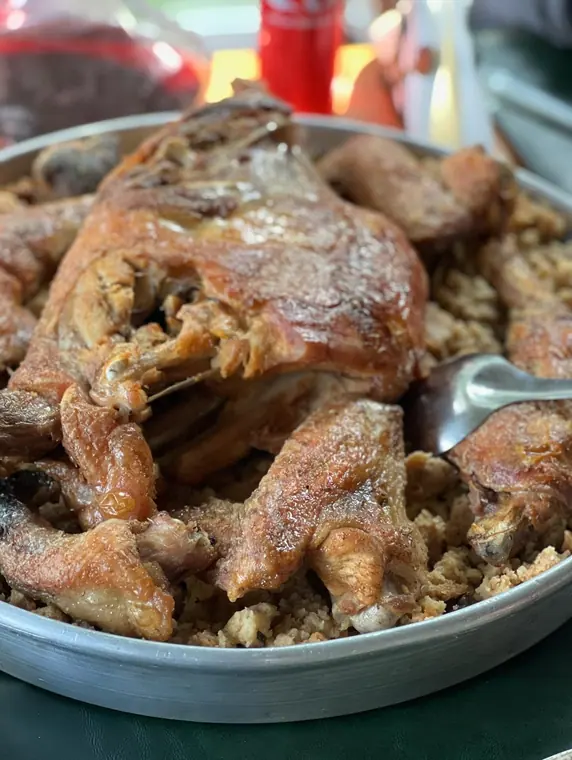 Roast poultry pieces on bulgur in metal tray