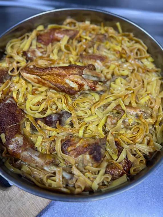 Roasted chicken pieces buried in buttered noodles