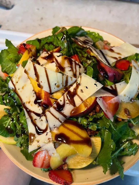 Rocket salad with cheese shavings, peach slices and balsamic