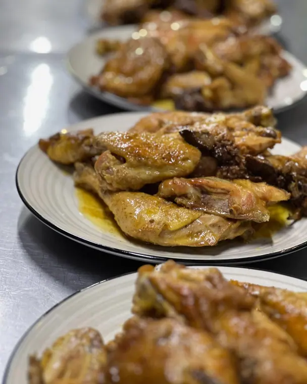 Row of plates of roasted chicken, middle plate in focus