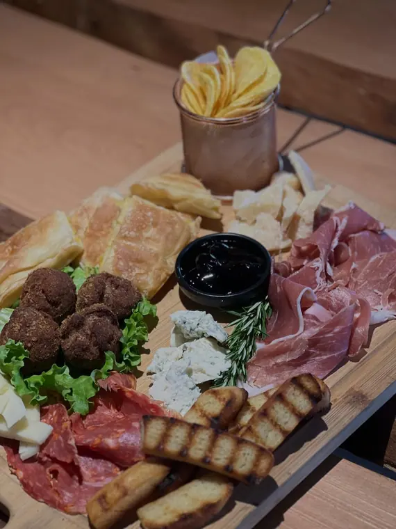 Sharing board of cured meats, cheese, bread and dip
