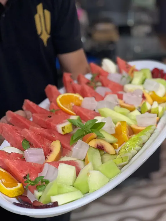 Staff member holding large mixed fruit platter