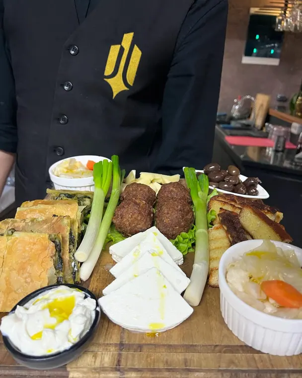 Staff member holds mixed starter board in front of a bar