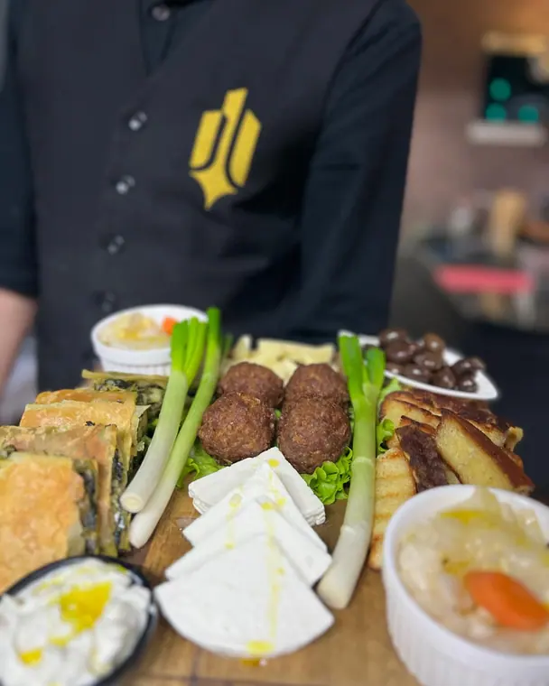 Starter board with pie, meatballs, feta and spring onions