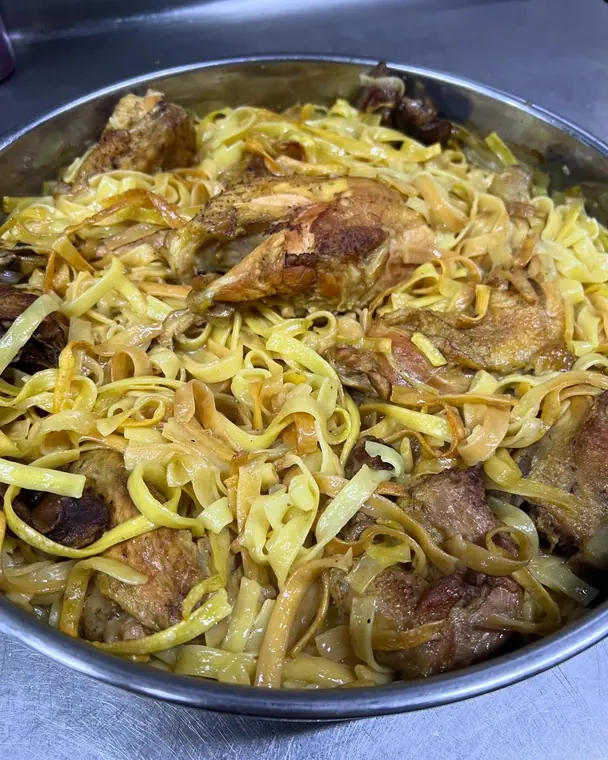 Tagliatelle with roasted chicken pieces in a metal pan