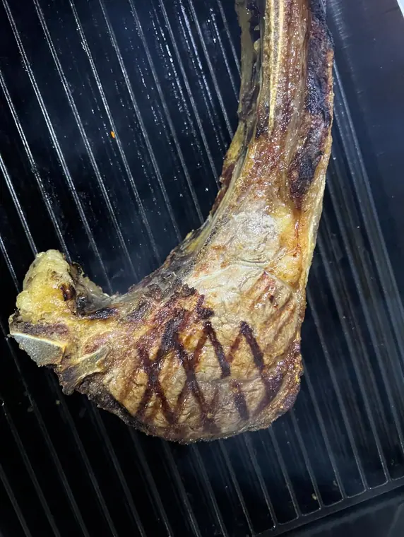 Tomahawk beef chop with grill marks on a griddle plate