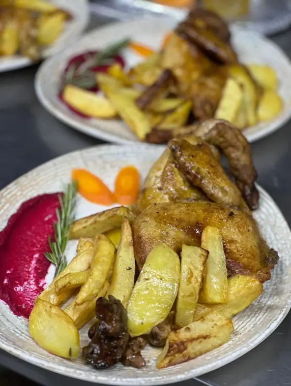 Two plates of roast chicken with potatoes and beetroot puree