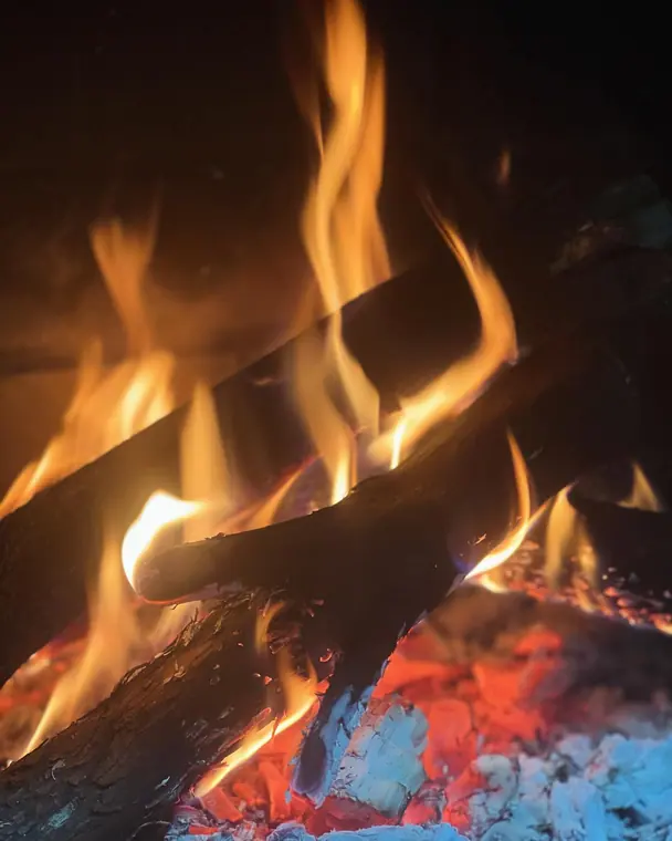 Burning logs and embers in a fireplace