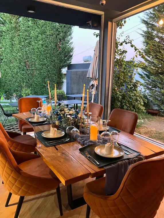 Corner table set for four with candles and garden beyond