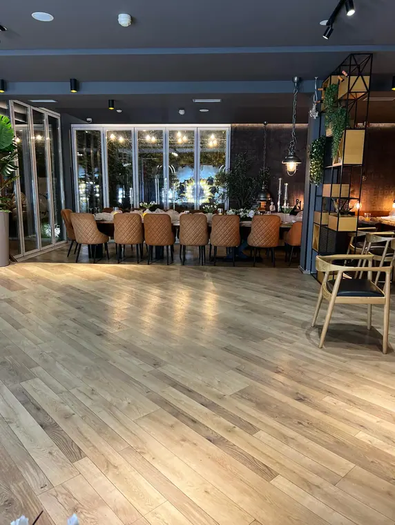 Dining room with open floor and set banquet table by glass doors